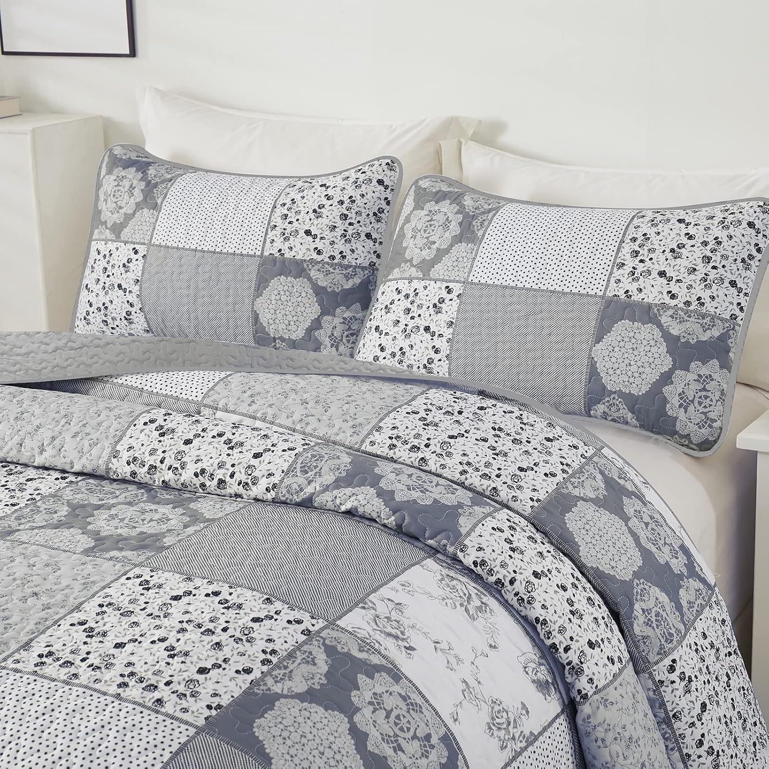 Quilted coverlet and two pillowcases with blue and white patchwork floral prints