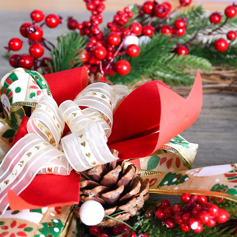 Wreath close-up of pinecones, white-red ribbon bows, and red berry accents
