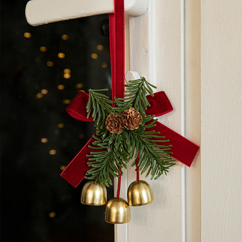 Evergreen pinecone door ornament with gold bells and red hanging ribbon
