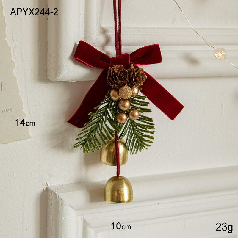 Hanging Christmas ornament with red velvet bow, pinecones, evergreen sprigs, and gold bell drops