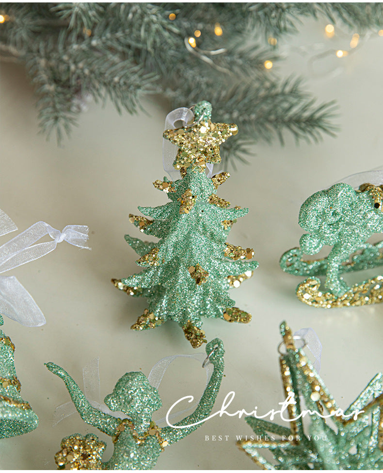 Green glitter hanging tree ornament with gold star top, shown among other ornaments
