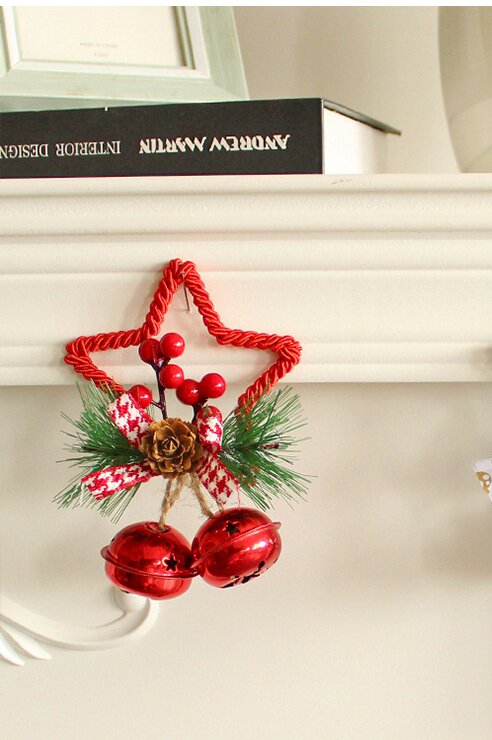 Red star ornament with pine needles, pinecone, ribbon bow, and two red bell charms