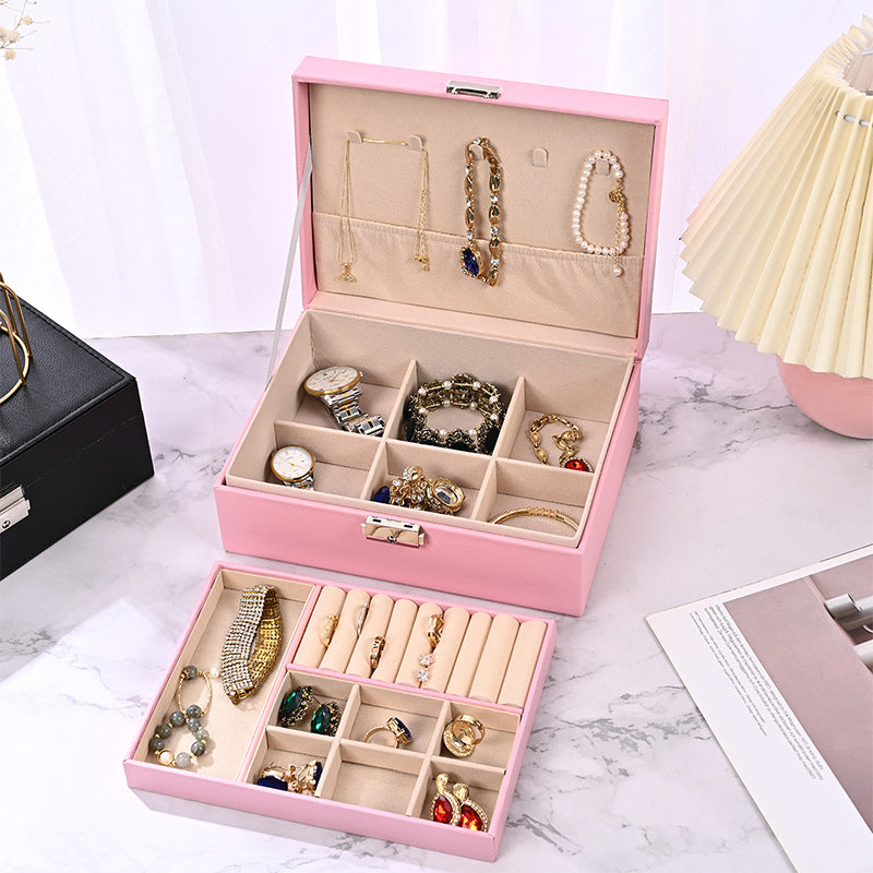 Pink jewelry organizer box open with padded compartments for rings, necklaces, and bracelets
