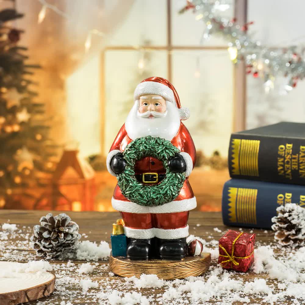 Santa Claus figurine holding green wreath, red suit, black boots on wooden base