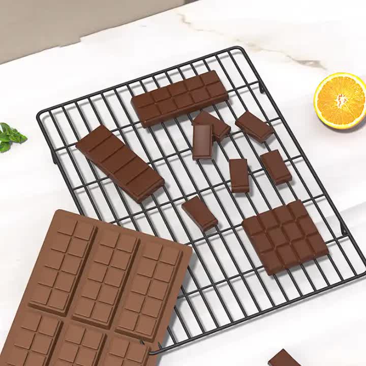 Silicone chocolate bar mold with rectangular cavities and dark brown chocolate pieces