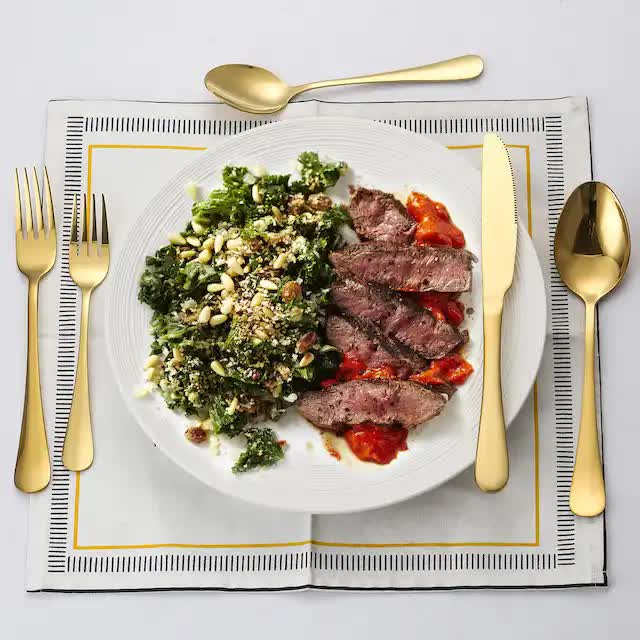 Gold stainless steel cutlery set with fork, knife, and spoon on a plate