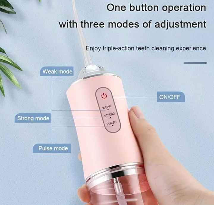 Pink portable water flosser in hand with one-button controls