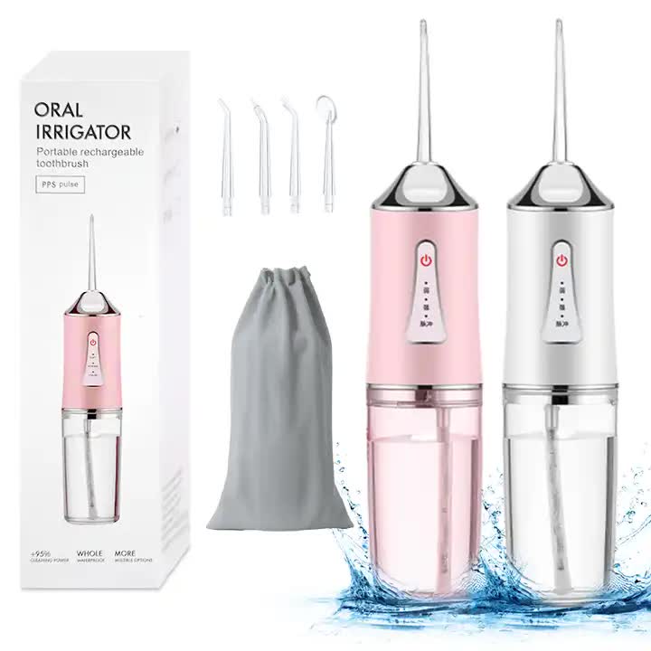 Portable oral irrigator kit with pink and white units, jets, and drawstring bag