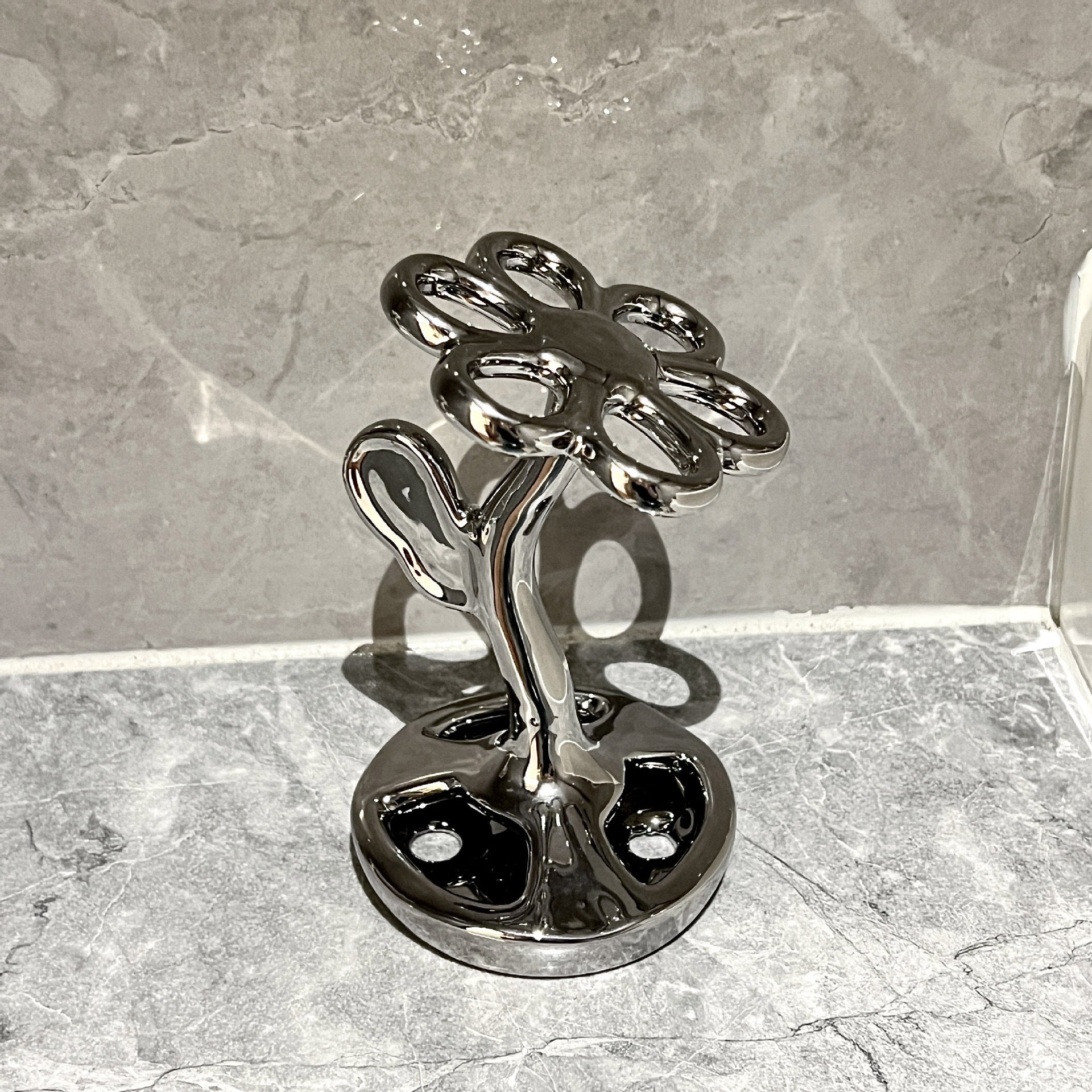 Ceramic flower toothbrush holder with glossy dark silver finish, vertical slots