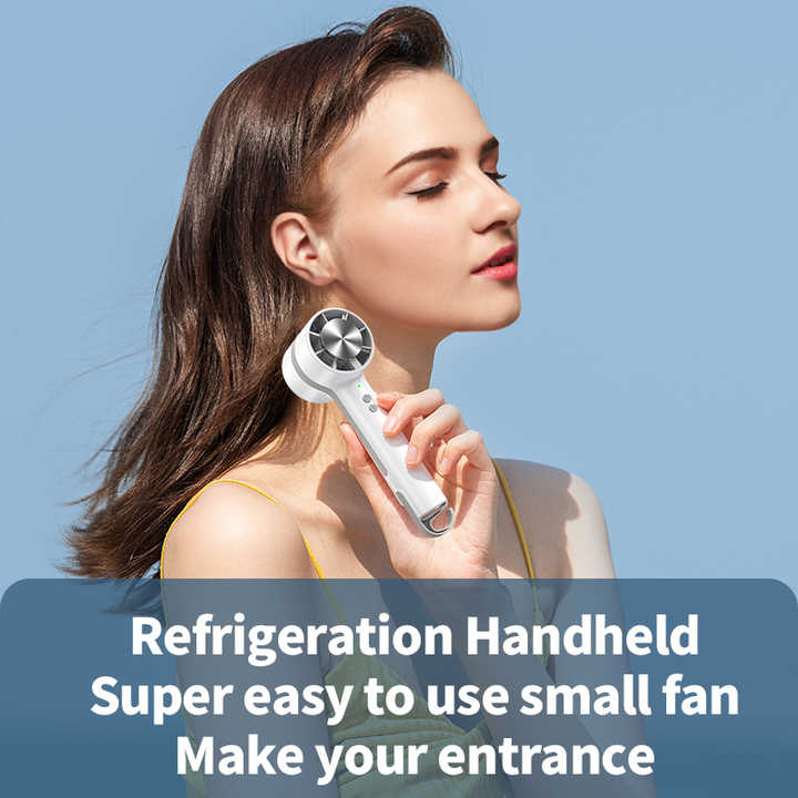 White handheld mini cooling fan with silver grille, held near the neck
