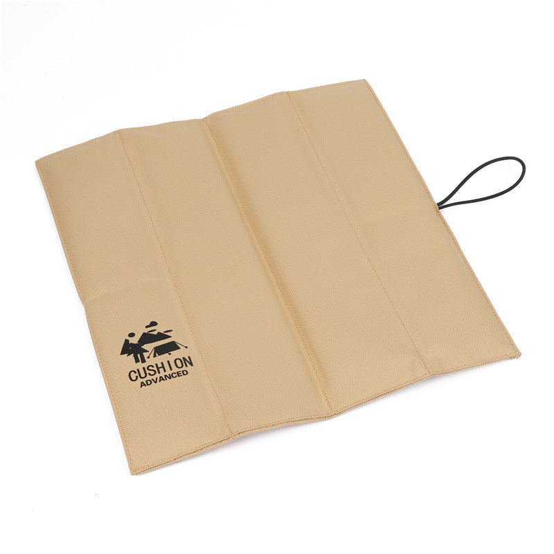 Foldable beige outdoor picnic seat pad with carrying cord and stitched panels