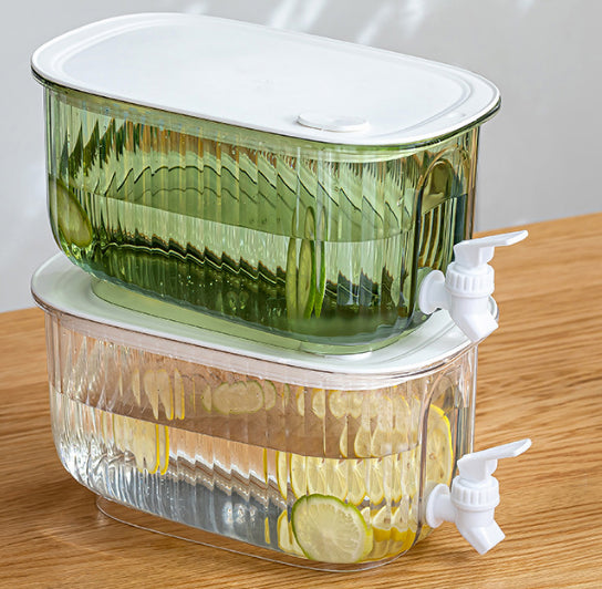 Stacked juice dispenser pitchers with white lids and spigots, side view on a table