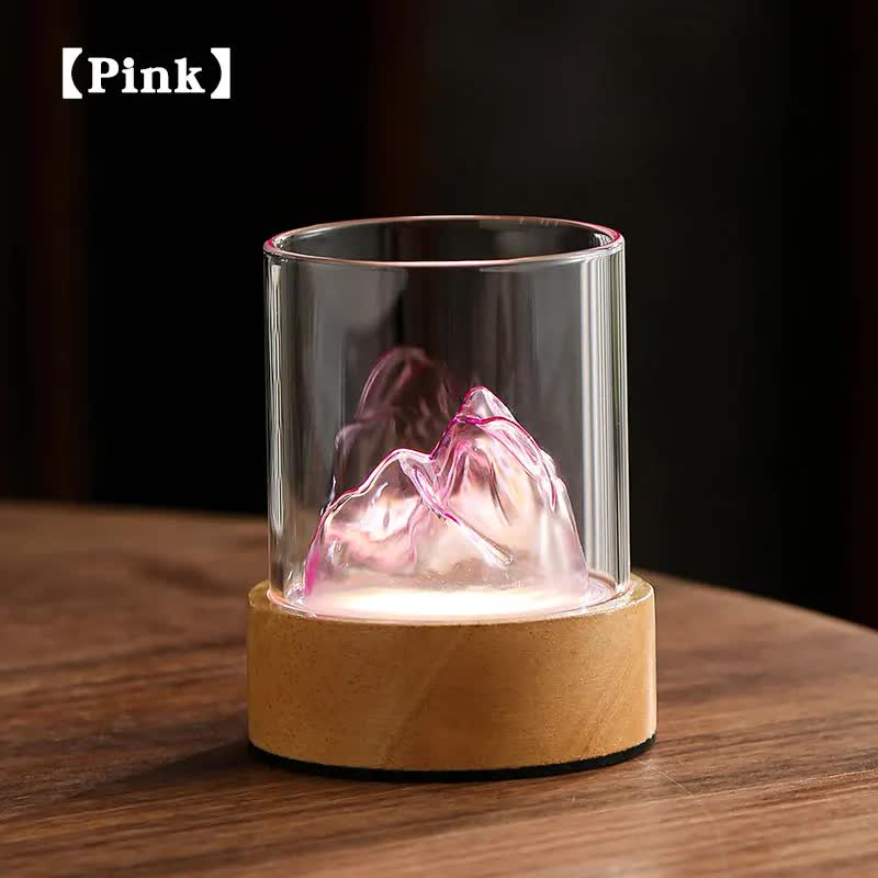Glass mountain night light with pink glowing lamp inside glass cylinder and cork base