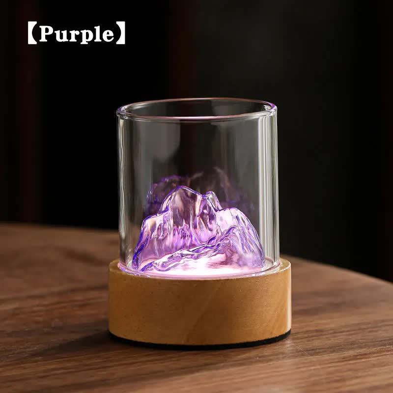 Glass mountain night light with purple glow in clear cylinder over cork base