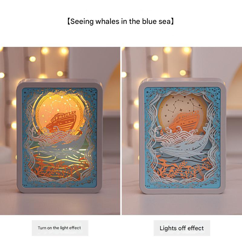 3D paper carving night light with whale-in-sea illustration, warm light on
