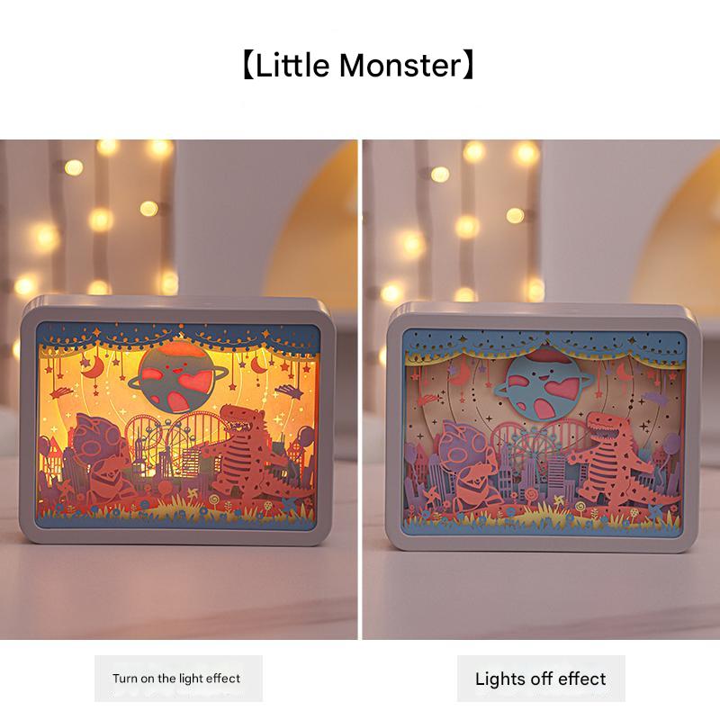 3D paper carving night light with grey frame, lit scene of monsters and stars