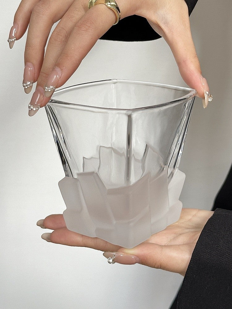 White frosted ice-cube textured glass tumbler with clear upper, held in hands