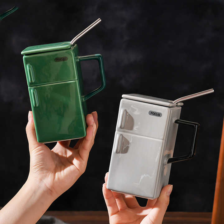 Ceramic mugs in green and light gray with straws and flip lids, side handles