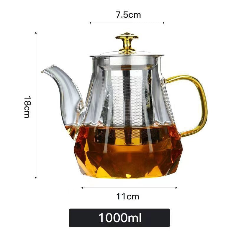 Glass teapot with gold handle and stainless infuser, filled with amber tea