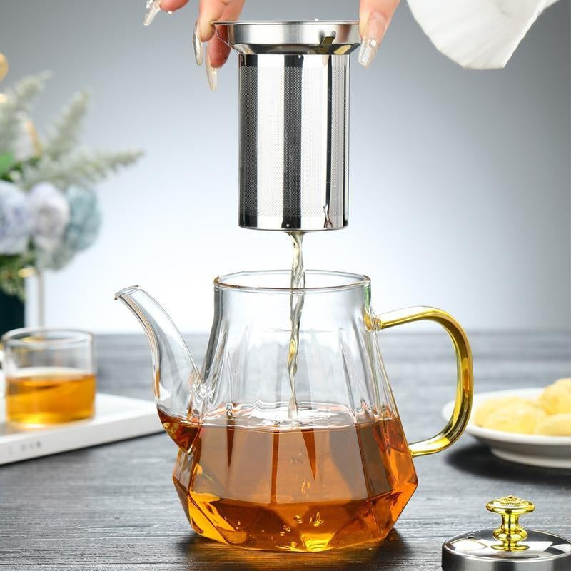 Glass teapot with stainless infuser, amber tea pouring into the glass body