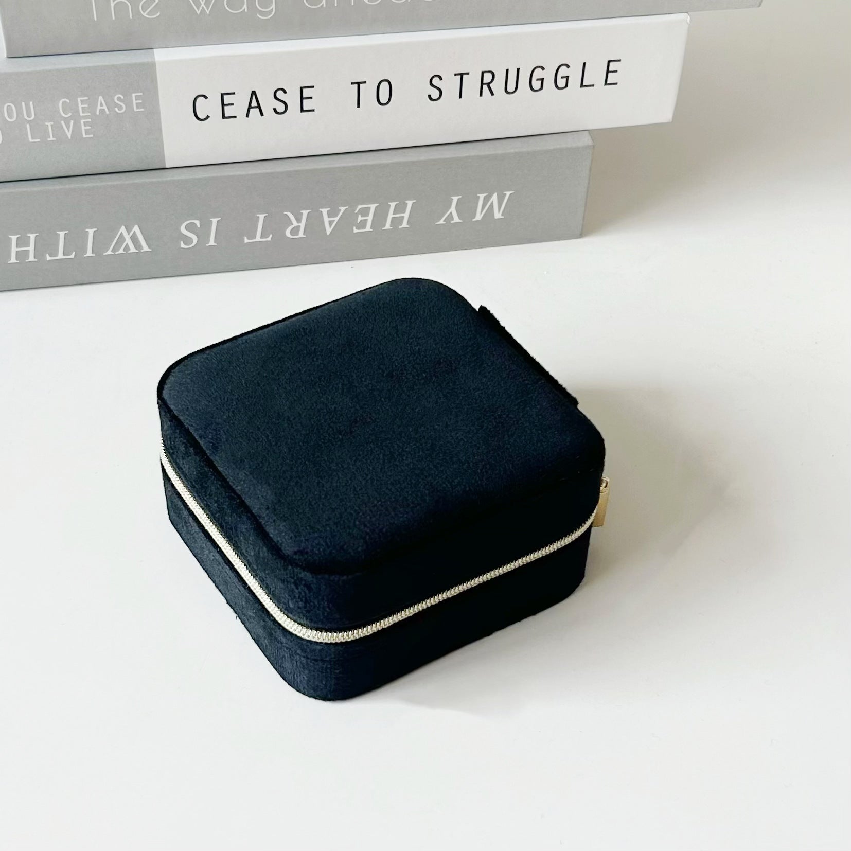 Black portable jewelry box with hinged lid and compact zippered exterior