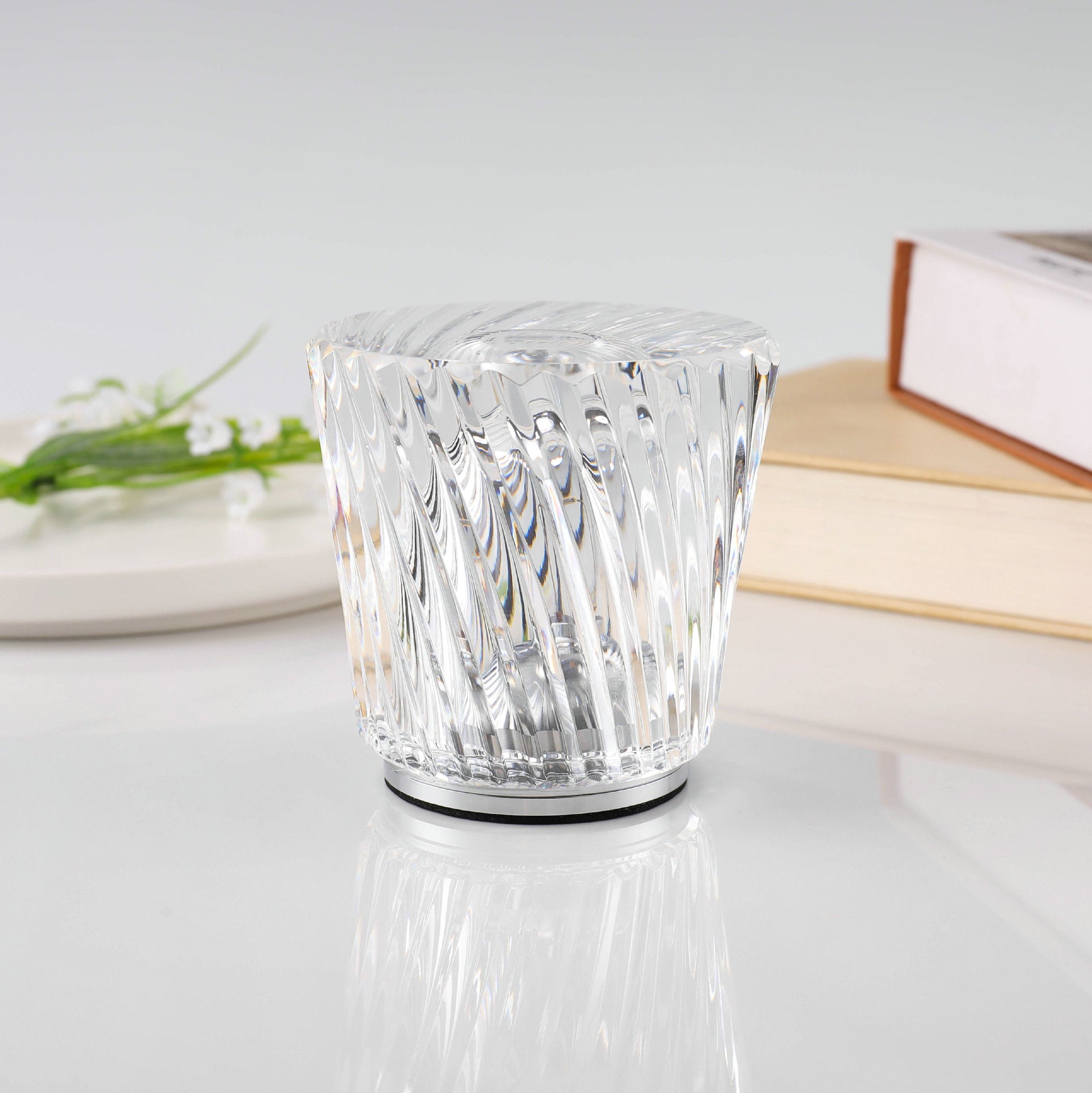 Clear crystal LED table lamp with faceted sides and round metal base