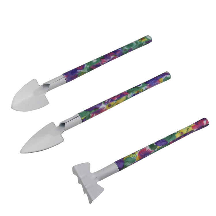 Hand gardening tools with floral-pattern handles, three metal shovels and trowels
