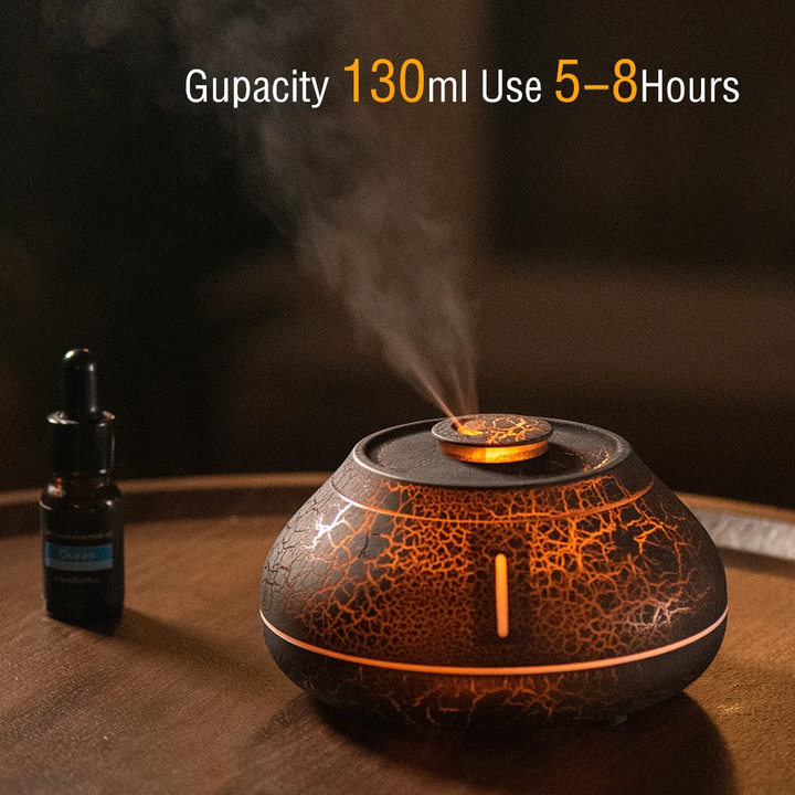 Aroma diffuser with warm LED glow, visible mist, and textured dark base