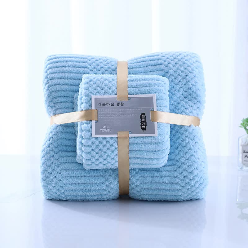 Light blue coral fleece towel set, two rolled towels with beige straps and labels