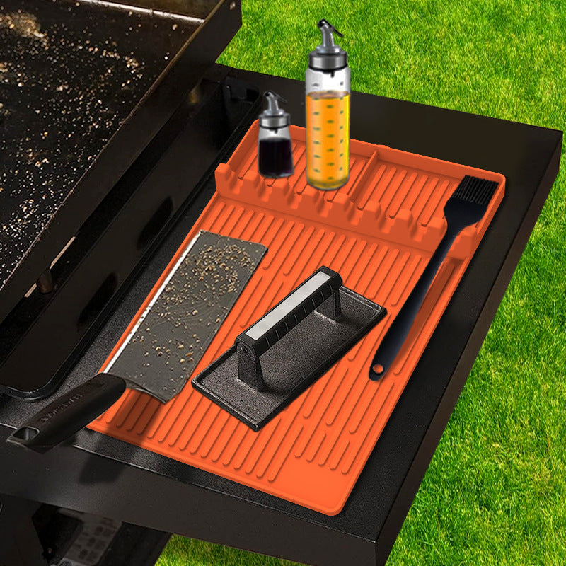 Orange silicone side rack protector mat with ridges on a grill tray