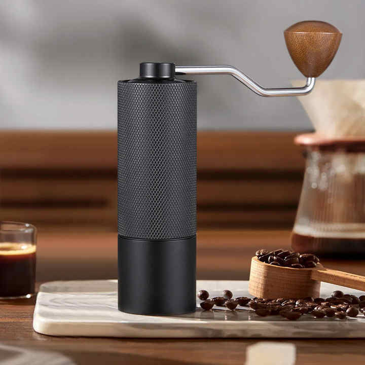 Manual coffee grinder with black textured body and wooden crank handle