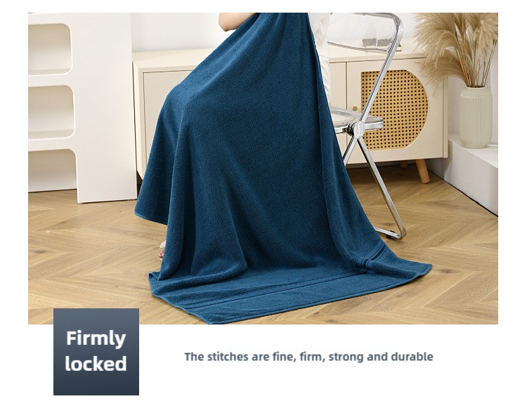 Blue cotton bath towel draped on rack, stitched terry fabric visible
