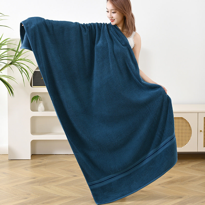 Towel set with dark blue bath towel, folded and draped over a person’s shoulders
