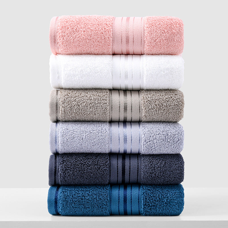 Towel set of folded towels in pink, white, gray, and dark blue shades, stacked