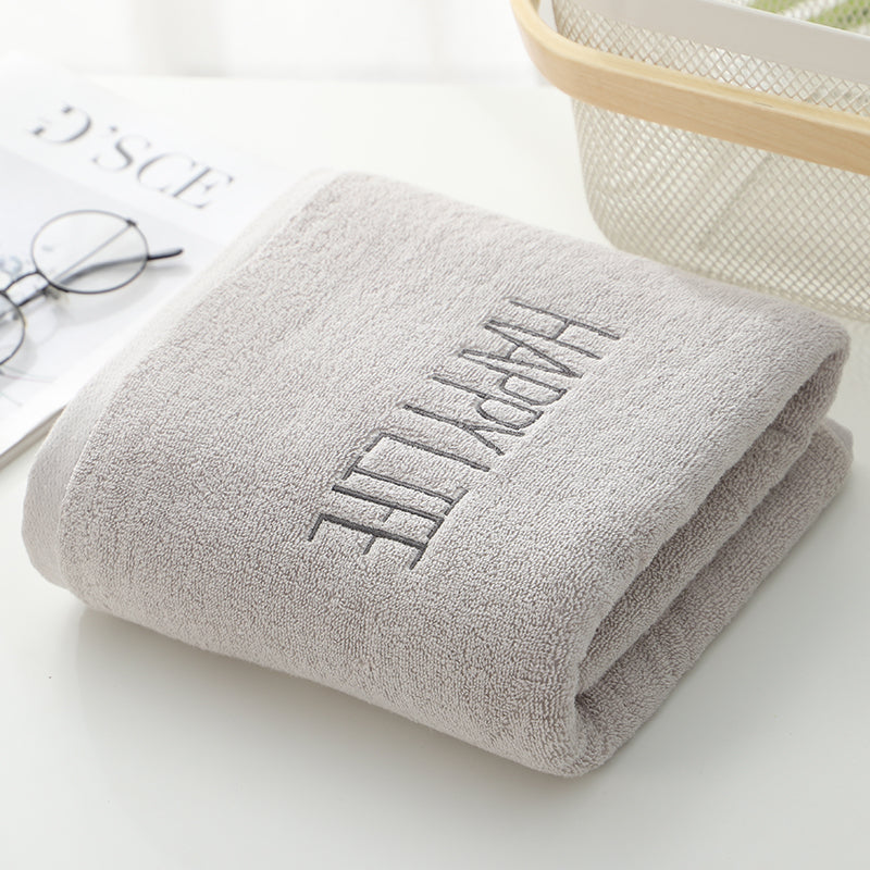Light gray bath towel with folded edge and embroidered logo text