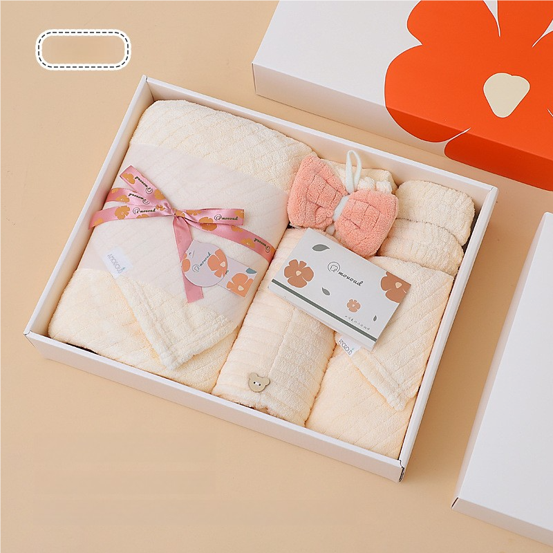 Towel gift set in open gift box with folded towels and small matching wash items