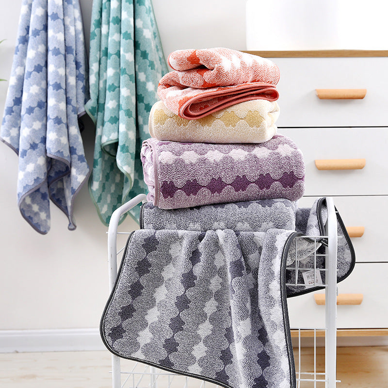 Coral and gray coral-fleece towel stack on rack, with patterned towels