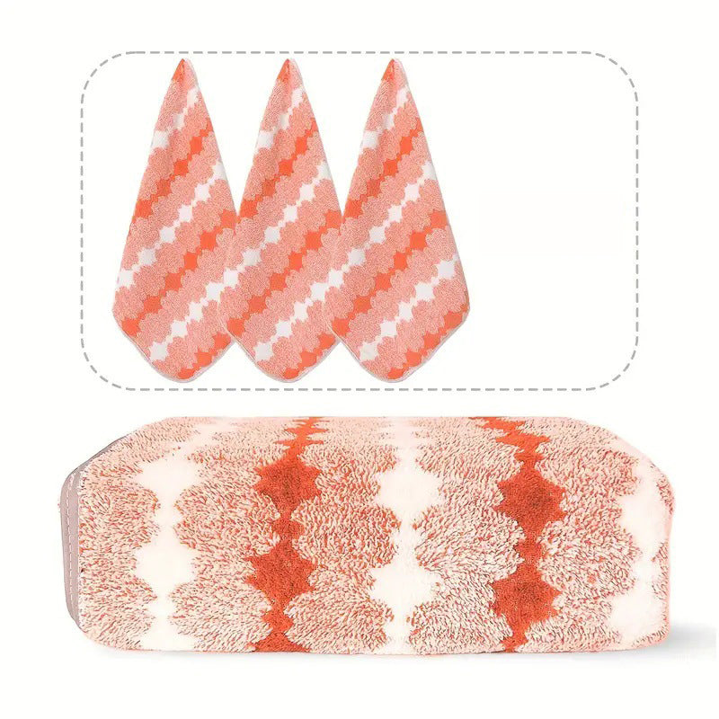 Coral fleece towel set with three folded towels, orange and cream geometric pattern