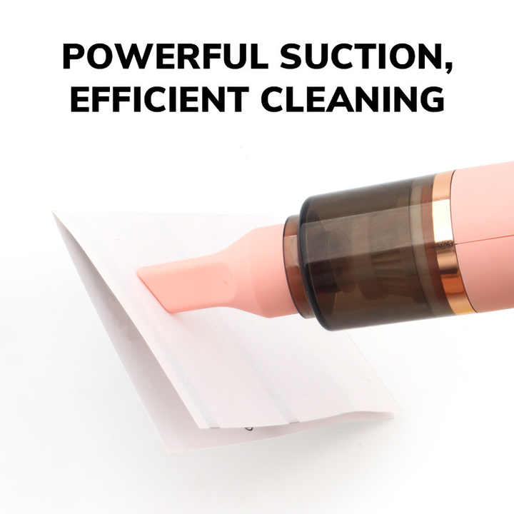 Pink handheld dust vacuum nozzle cleaning a crevice