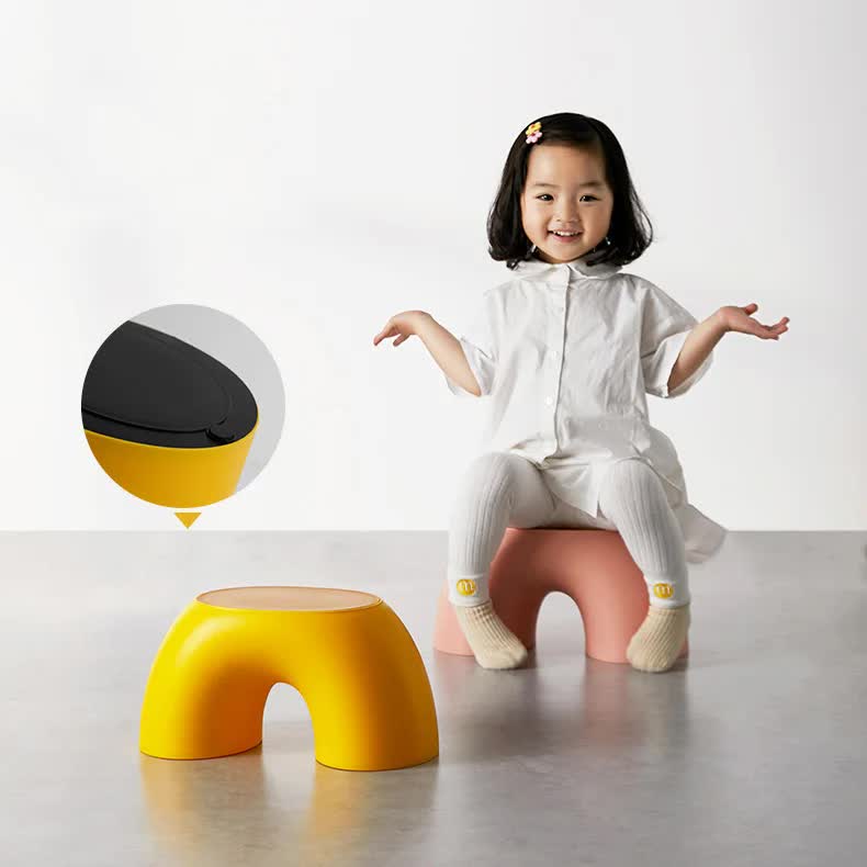 Yellow round plastic footstool with arched opening, curved low design for kids