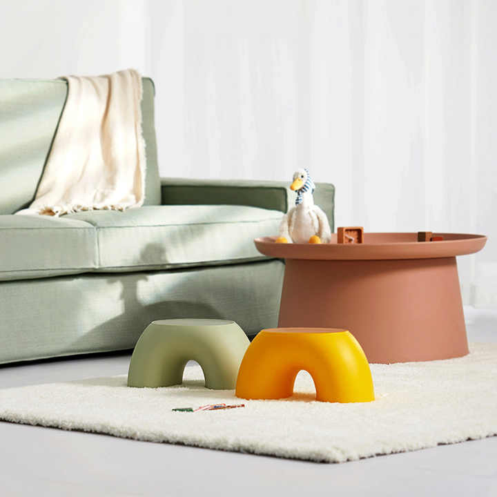 Playroom footstools: green and orange round plastic stools with arched openings