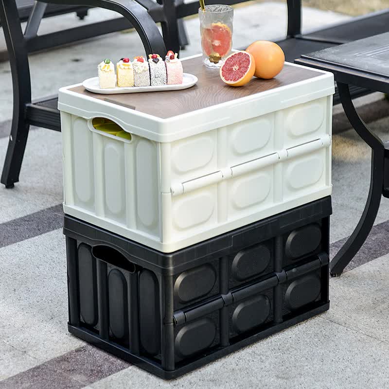 Foldable storage box set, white top section and dark base with lid on table.