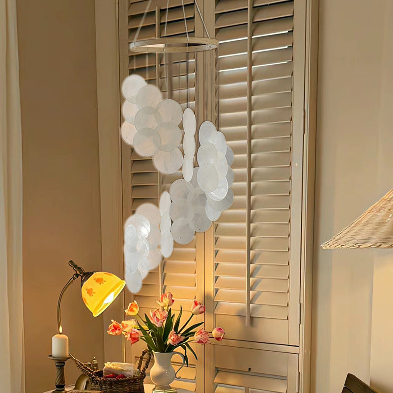 White seashell wind chime with hanging circular discs in clustered layers