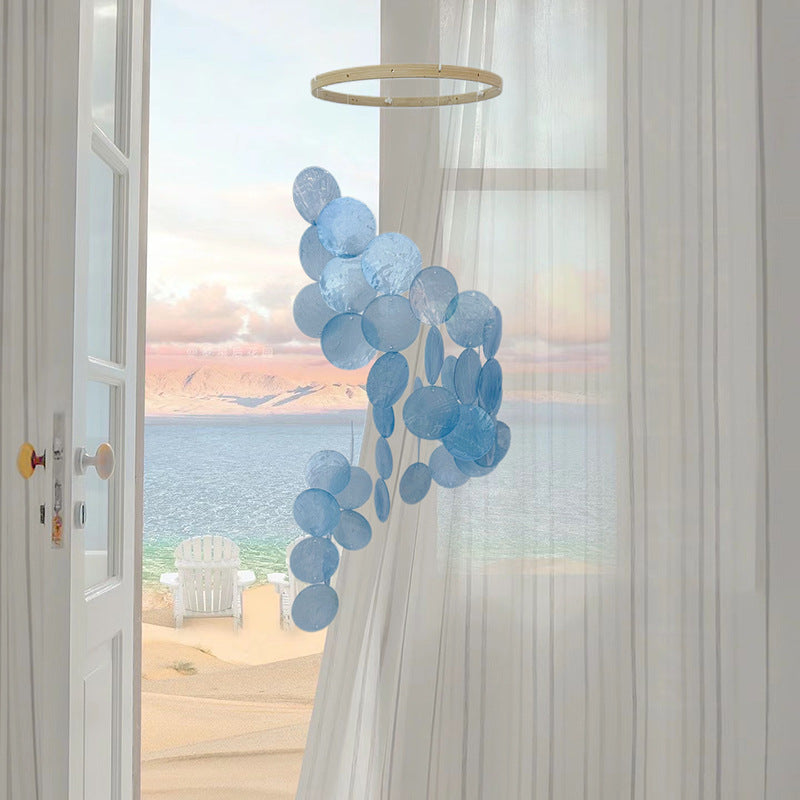 Blue seashell wind chime with circular shell charms hanging on a ring