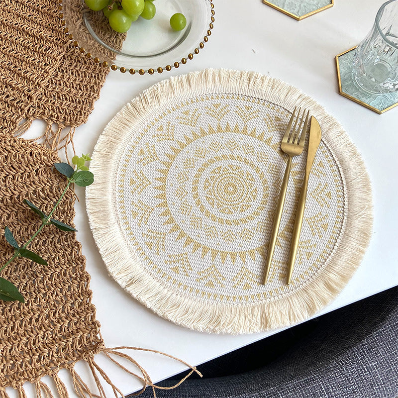 Round woven cotton placemat with tassel fringe, beige base and yellow boho pattern