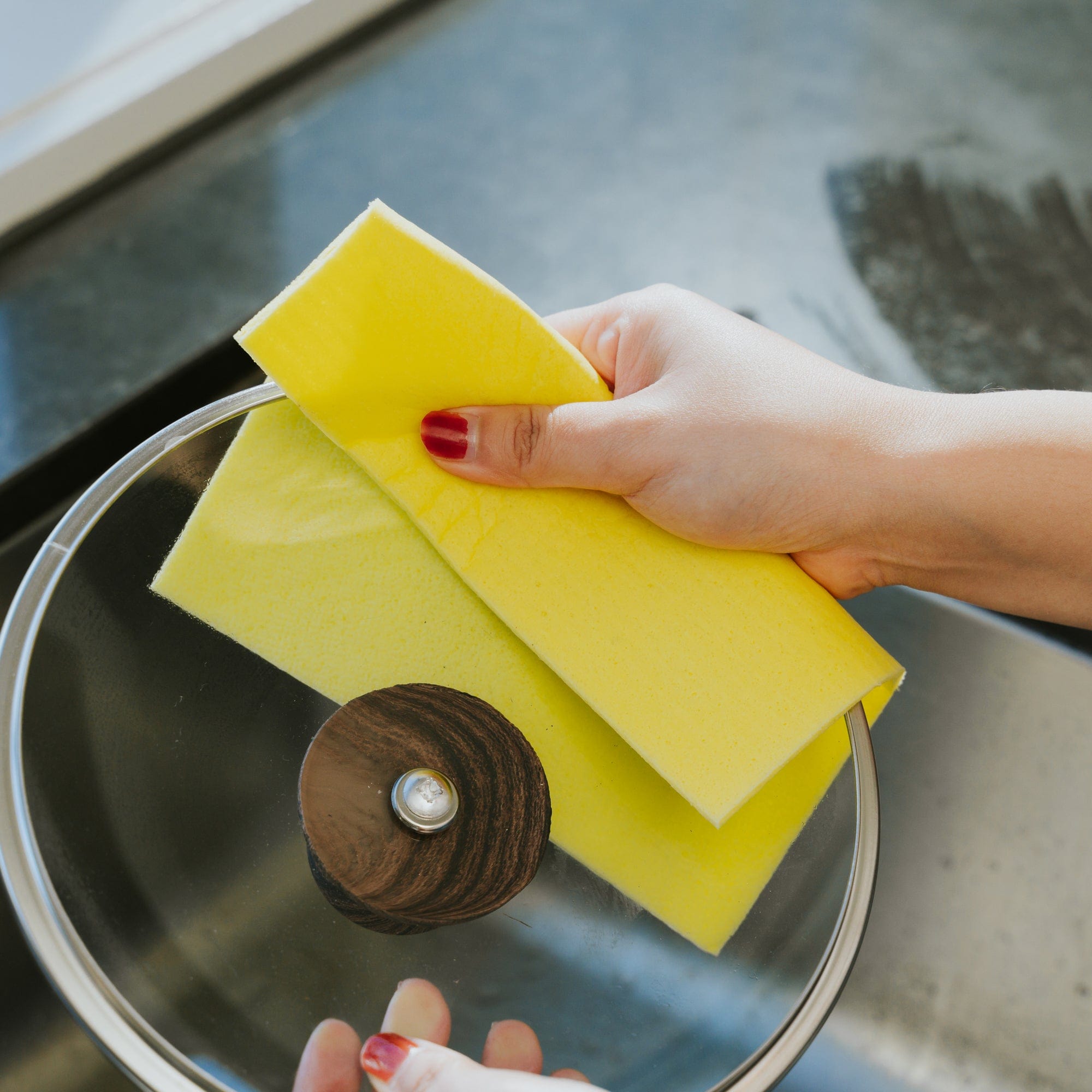Antibacterial cellulose cloth, 15cm, yellow cloth held above metal sink