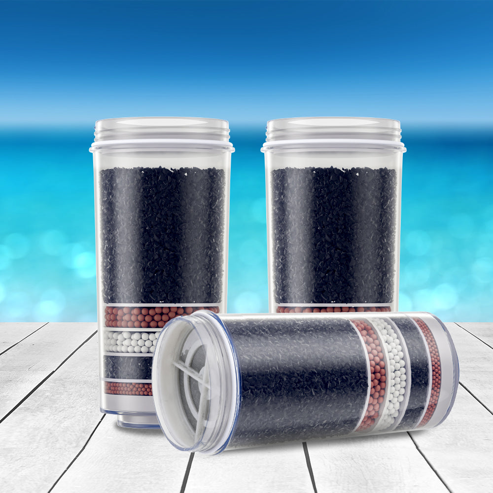 Clear canister water filter cartridge with layered dark, red, and white media
