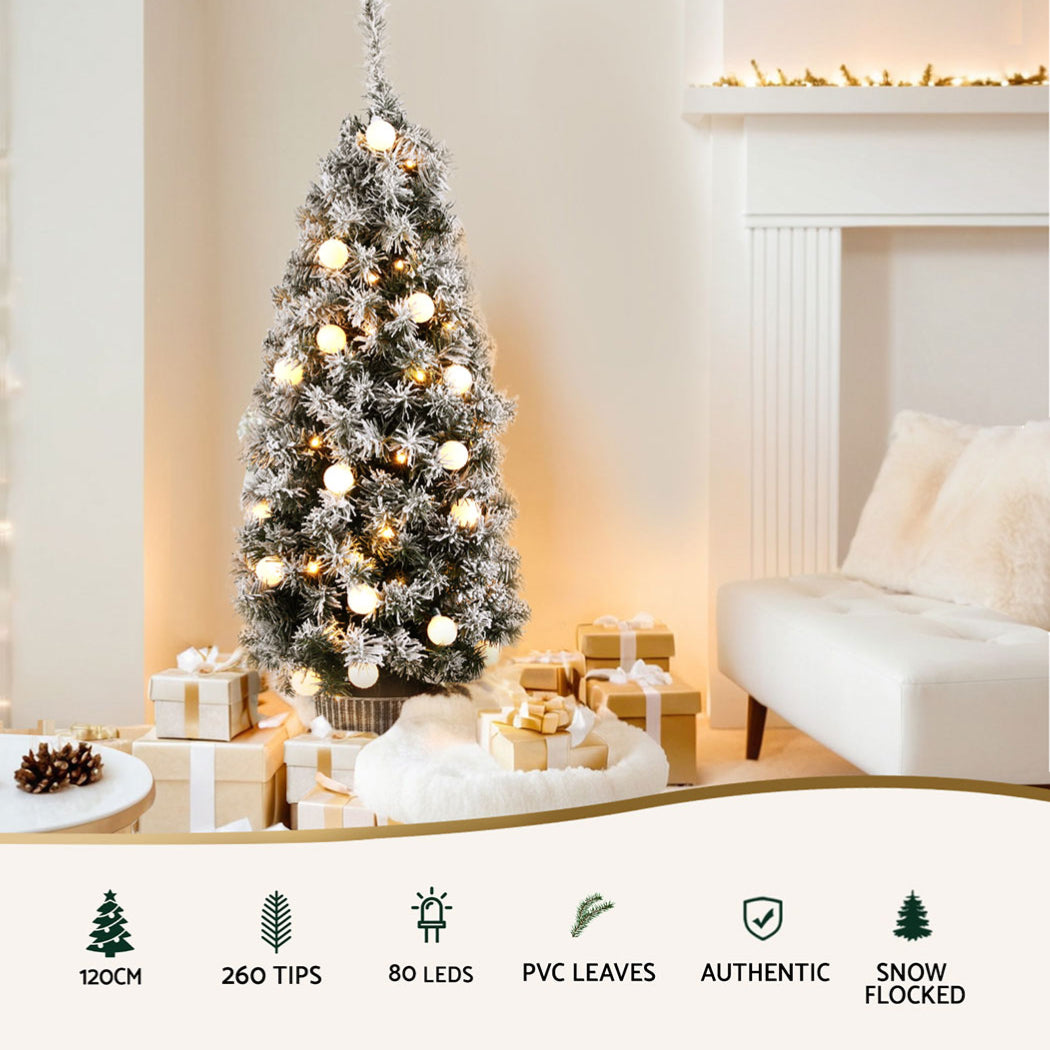 Snowy potted Christmas tree with warm white lights and white bauble decorations