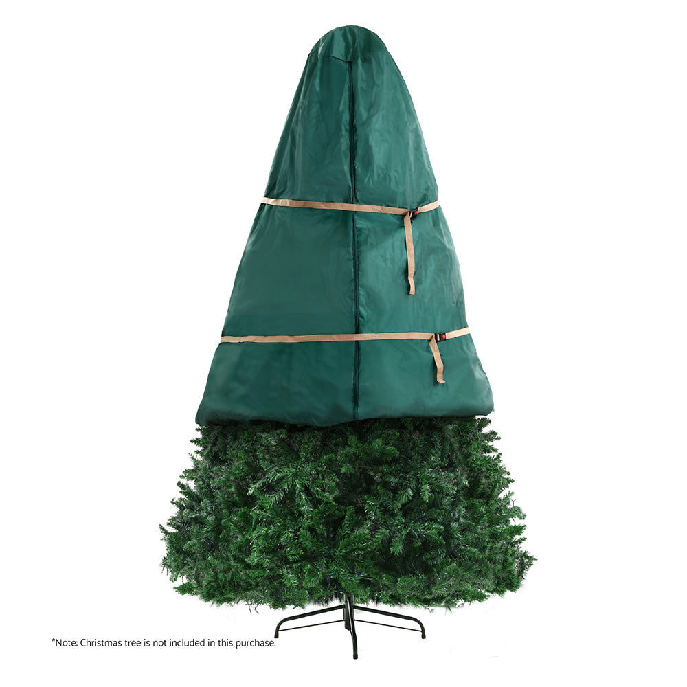 Green Christmas tree storage bag open around an artificial tree, with strap bands