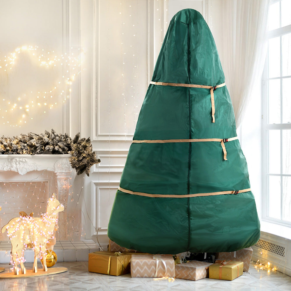 Green Christmas tree storage bag with straps and top cover, set on metal stand